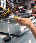 Person using Klein Tools 3-In-1 Flip Impact Socket Set for Quick Drive Size Swaps on electrical machinery.