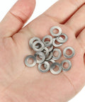 Hand holding 304 Stainless Steel Belleville Washer M5x10mm Conical Knurled Pack Of 50, showcasing durability and size.