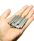 Hand holding sturdy 6mm dowel pins set for shelves and woodworking, 15 pack, 50mm length, 304 stainless steel, M6 dowels, ground.