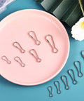 Premium 304 Stainless Steel Spring Hooks Set 250 Pieces in Six Sizes displayed on a pink plate