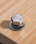 Stainless steel hex head bolt with washer resting on a wooden surface