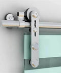 Close-up of Heavy Duty 12Ft Sliding Barn Door Hardware Kit With Stainless Steel Track System installed on a glass door