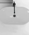 Top view of a sleek white Bathroom Sink Modern Minimalist Art Basin Hotel Bathroom Ceramic Above Counter Basin with black faucet.