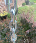 Close-up of bright zinc-plated metal chain outdoors, 3/16-IN X 10-FT Heavy Duty Proof Coil Chain, 800lbs Safe Load Capacity