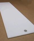 Tough As Nails White UHMW Polyethylene Sheet Five Sixteenth Inch Thick Twelve By Forty Eight Inches Standard Heavy Duty Low Friction Wear Resistant Material Meets ASTM D 4020 05, side view on brown surface.