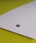Virgin PTFE Sheet One Eighth Inch Thick, Twelve By Forty Eight Inches, shown on yellow surface, coin for scale.