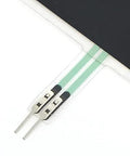 Close-up of FSR502 force sensing resistor with green flexible film and two metal leads.