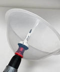Close-up of clear collapsible dust bowl accessory for hole saws mounted on a drill with arbor