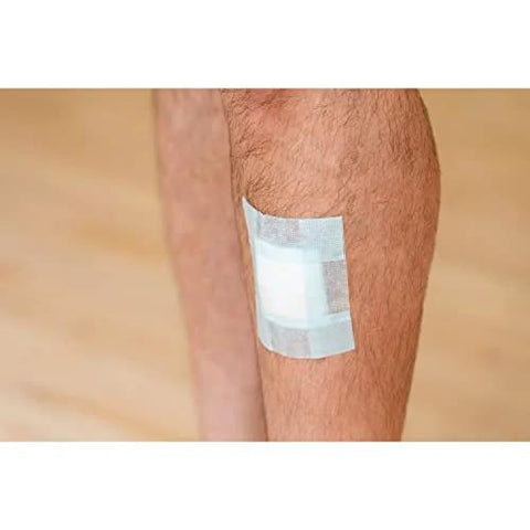 Nexcare bandage tape on leg; white adhesive pad with clear surrounding tape, gentle for sensitive skin.