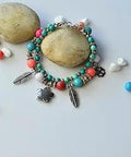Colorful bracelet made with Antique Silver Tibetan Style Pumpkin Spacer Beads 4mm, adorned with feather and flower charms.