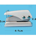 Side view of white handheld hole punch tool showing dimensions; related to Two Pack Small Black And White One Quarter Inch Circle Hole Punch Handheld Tool For Paper And Leather Craft Clean Cut Mess Free Grab And Go Portable Easy To Use Durable Metal For Long Lasting Use Punches Through About Ten Sheets Of Paper Or Leather.