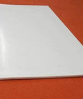Sheet Three Sixteenth Inch Thick By Twelve By Twenty Four Inches Of PTFE for nonstick surfaces, low friction, on orange background