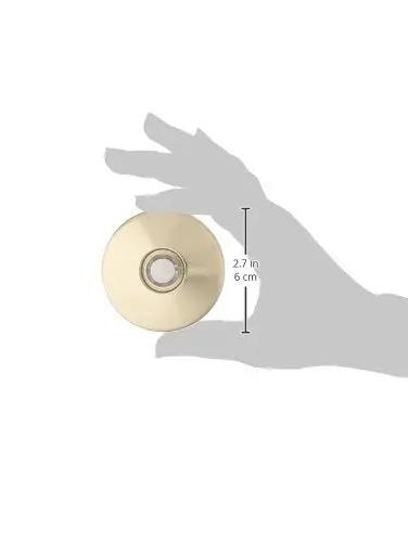 Hand holding lit stucco pushbutton doorbell button with gold rim pearl button 5/8 inch diameter and 2-1/2 inch gold anodized plate