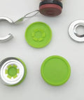 Top-down view of several empty 10ml borosilicate glass lab vial components with green caps and aluminum flip-off closures
