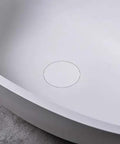 Close-up of the interior of a Real Deal White Oval Vessel Sink Built Tough From Dense Artificial Stone with drain hole.