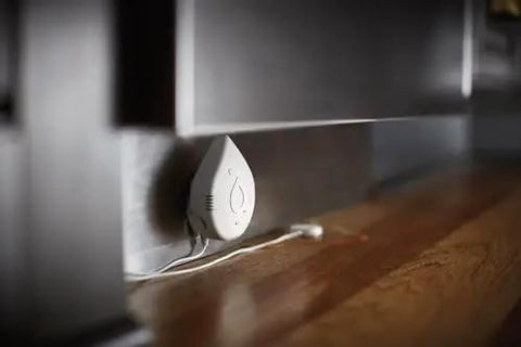 Flo Smart Water Leak Detector 3 Pack device installed under cabinet for home water sensor alarm with real-time alerts and round-the-clock monitoring.