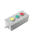 Angled view of a metal push-button control box with yellow, green, and red buttons and side cable gland.
