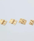 1:12 Scale Miniature Door Hinges With Screws, Set Of 4 For Dollhouse Doors And Cabinets. Display of four brass-colored hinges.