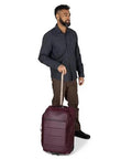 Osprey Ozone 2-Wheel Carry-On luggage in burgundy with extended retractable handle, rolling on two wheels