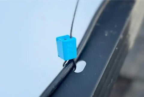 Top Shelf 24 Inch Solar Cable Management Clips 50 Pack Reusable Wire Organizers Tool Free Installation Saves Serious Labor On Rooftop Panels With A Kickass Grip That Keeps Wiring Tight, blue clip securing cable.