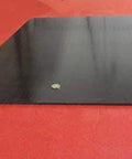 UHMW PE Black Sheet 1/4 Inch Thick 24 By 36 Inches shown on red surface, durable and wear-resistant plastic panel for industrial use