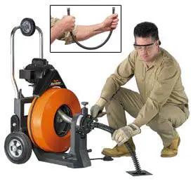 Badass Power Feed Drain Snake Machine with 100 foot cable, used by an operator for clearing blocked pipes.