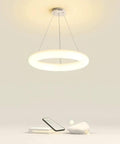 White Ring Acrylic LED Pendant Light for Bedroom, Modern Hanging Lamp, glowing on minimalist background