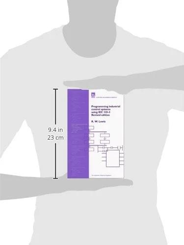 Book titled Programming Industrial Control Systems Using IEC 1131-3, purple spine and white cover, held by a person