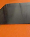 UHMW PE Black Sheet 1/4 Inch Thick 24 By 36 Inches Built To Last Durable Wear Resistant Plastic Panel, side view on orange surface.