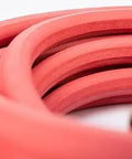 Close-up of coiled All Rubber Hot And Cold Water Hose, 5/8 Inch By 50 Feet, with rigid sleeve, crush resistant and durable construction.