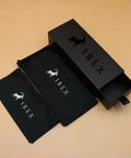 Black IBEX-branded box and cloth pouch for sunglasses set on a beige background