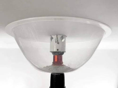 Clear plastic dust bowl attachment for hole saws with metal mandrel, front view.