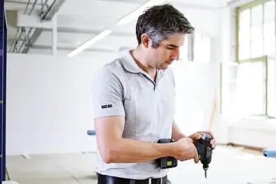 Professional 18V Cordless Drill And Driver Tool With Quick Change Chuck System Hella Versatile For Wood Metal And Garage Work Smooth Grip Fast Charge Battery Included Bright Led Light Variable Speed Trigger Top Tier Performance Rig in use by a man.