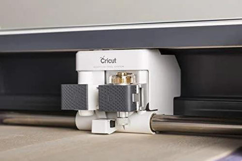 Cricut knife blade and drive housing installed under Cricut Maker; white unit with gray grips and gold screws.