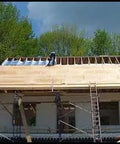 Heavy Duty Reflective Insulation Roll With Foam Core Covers 400 Square Feet being installed on the roof of a building.