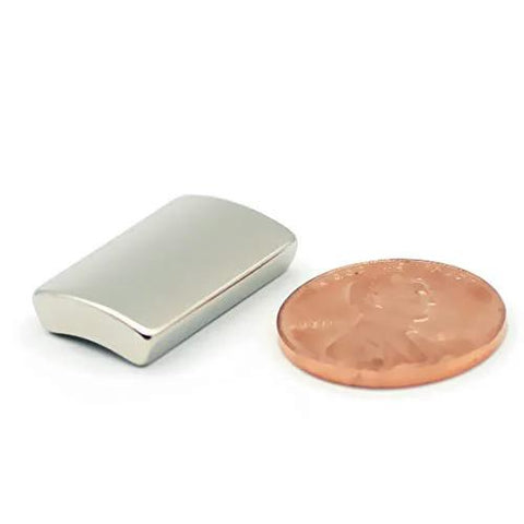 NdFeB arc-segment magnet, silver, with a penny for scale
