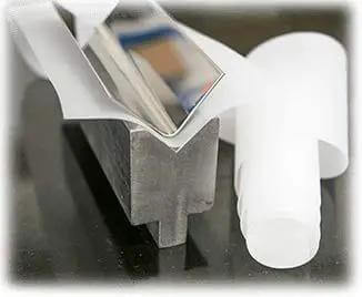 Six Inch By 0.030 Inch By 100 Foot Urethane Die Protection Film for press brakes on metal surface