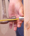 Southwire Smart Shield wire protection guard being installed on a yellow electrical wire beside a wooden stud