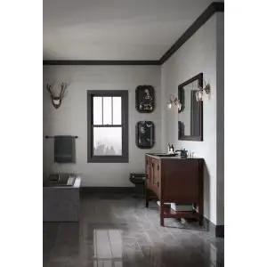 Modern bathroom featuring a bathtub, wooden vanity with sink, wall decor, and stylish lighting.