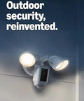 Ring Floodlight Cam Wired Plus outdoor security camera with dual floodlights, white, mounted on exterior wall.