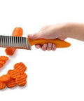 Crinkle cut knife with orange handle and stainless steel blade slicing carrot slices.