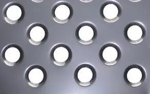 Close-up of sheet metal with dimples made by three piece dimple die set for metal fabrication in one half inch three quarter inch and one inch dies.