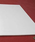 Sheet Three Sixteenth Inch Thick By Twelve By Twenty Four Inches Of PTFE on red background, nonstick low friction surface.
