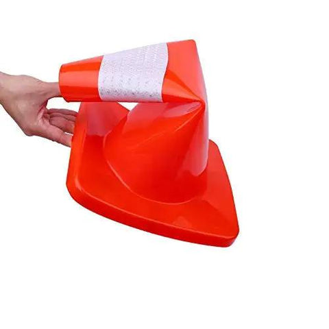 Person bending a 12 Pack 18 Inch PVC Traffic Cone For Road Work And Parking Lot Safety, showing its flexibility and durable construction.