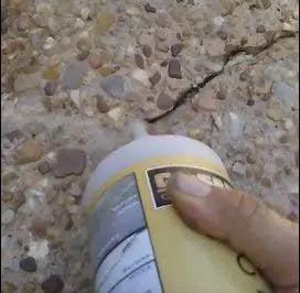 Applying Top Rated Stained Concrete Crack Filler For Driveway Patio Pool Deck Walkway Restoration Water Activated Heavy Duty Patch Mix In Mocha Brown Shade to a pavement crack.