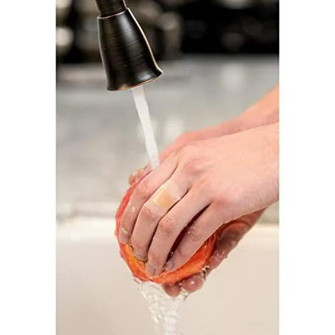 Person washing fruit under faucet wearing Waterproof Clear Bandage Assorted Sizes 100 Count With 360 Degree Seal Around The Pad