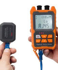 Front view of orange handheld optical fiber power meter with LCD, keypad, and VFL probe connected to blue fiber lead.