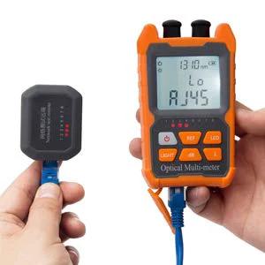 Front view of orange handheld optical fiber power meter with LCD, keypad, and VFL probe connected to blue fiber lead.