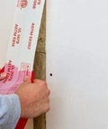 Applying Fire and Water Barrier Tape FWBT4 4 in x 75 ft to a construction joint for smoke and sound isolation.