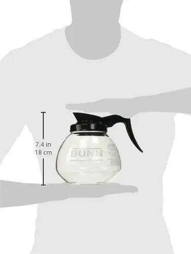 Person holding shatter-resistant glass carafe from Coffee Pot Decanter Carafe Set With 12 Cup Capacity, Three Pieces Including Two Black Regular And One Orange Decaf, Shatter Resistant Laboratory Grade Glass, Durable Easy Pour For Home Kitchen And Office Coffee Bar.